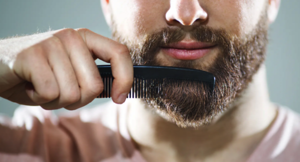 Hombre joven peínandose la barba