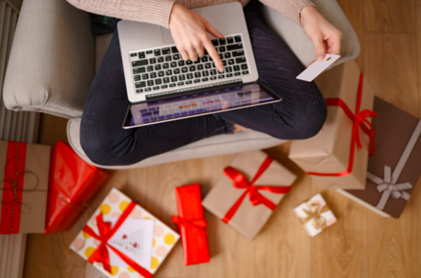 Manos femeninas con una laptop y una tarjeta de crédito