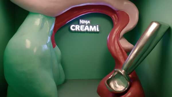 Foto de un fundererelele gigante con el logo de Creami Ninja de fondo en luces neón