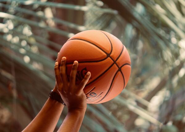 Manos masculinas sosteniendo un balón de basquet