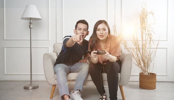 Hombre y mujer jóvenes jugando videojuegos