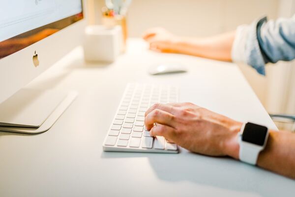 Manos masculinas, sobre un teclado, escribiendo