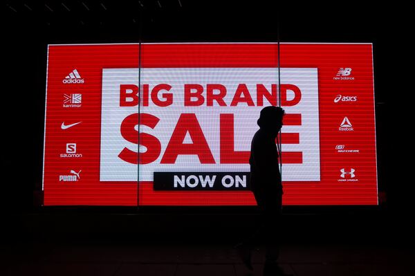 Silueta masculina caminando frente a un letrero que dice Big Brand Sale