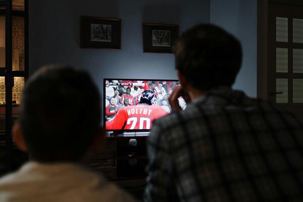 Padre e hijo mirando deportes en TV