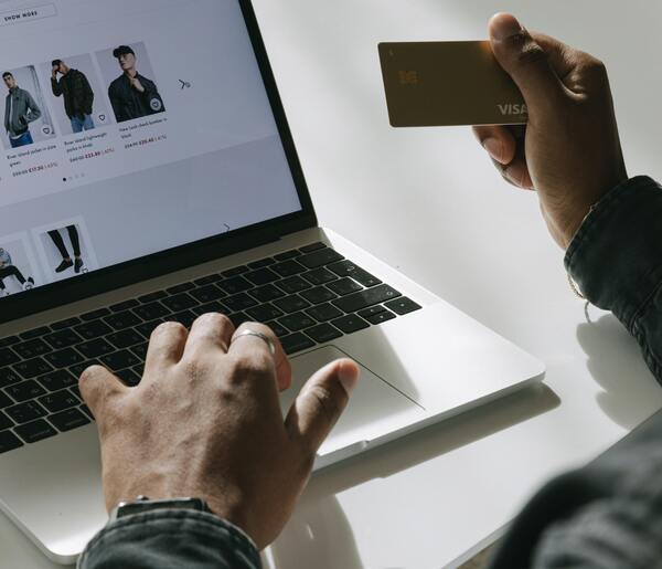 Hombre con la tarjeta de crédito en la mano para pagar su compra online