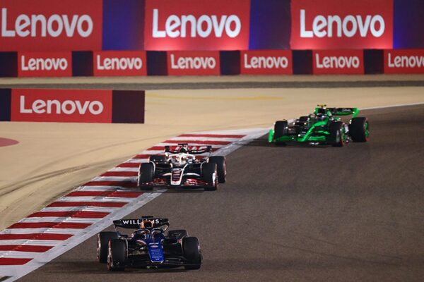 Foto de autos de carreras en una pista con logos de Lenovo de fondo