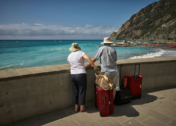 Turistas de pie frente al mar