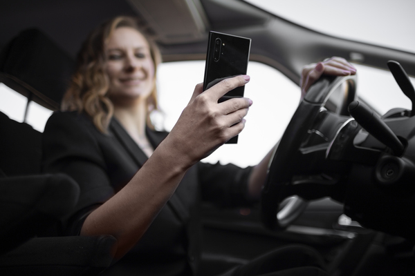 conductora de taxi de aplicación con el celular en la mano